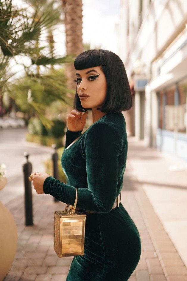 Photo by sparking.joy with the username @sparking.joy, who is a verified user,  November 22, 2023 at 6:45 PM. The post is about the topic tightdresses and the text says 'Madame sports her new velvet dress while out shopping. You're touching it and humping it in your mind, but you'll never get to touch it. #teaseanddenial #clothed #velvet #tightdress #green'