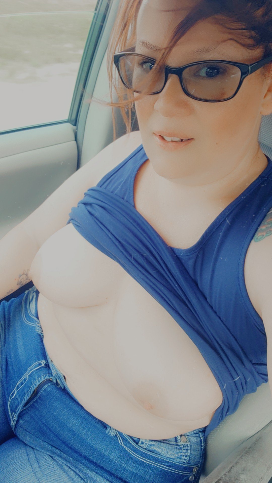 Photo by BothWaysEntwined with the username @BothWaysEntwined, who is a verified user,  May 20, 2024 at 6:35 PM and the text says 'Driving Topless on this hot 🔥 day😍 #titties #boobs #public #drivingtopless #amateur #milf #nakedinpublic'