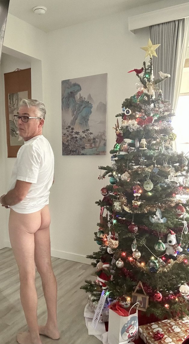 Album by Maturedad with the username @Maturedad, who is a verified user,  December 11, 2024 at 12:54 AM and the text says 'Daddy making me pose by the tree. Merry Christmas! 🎄'