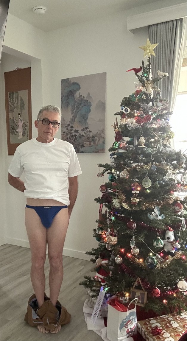 Album by Maturedad with the username @Maturedad, who is a verified user,  December 11, 2024 at 12:54 AM and the text says 'Daddy making me pose by the tree. Merry Christmas! 🎄'