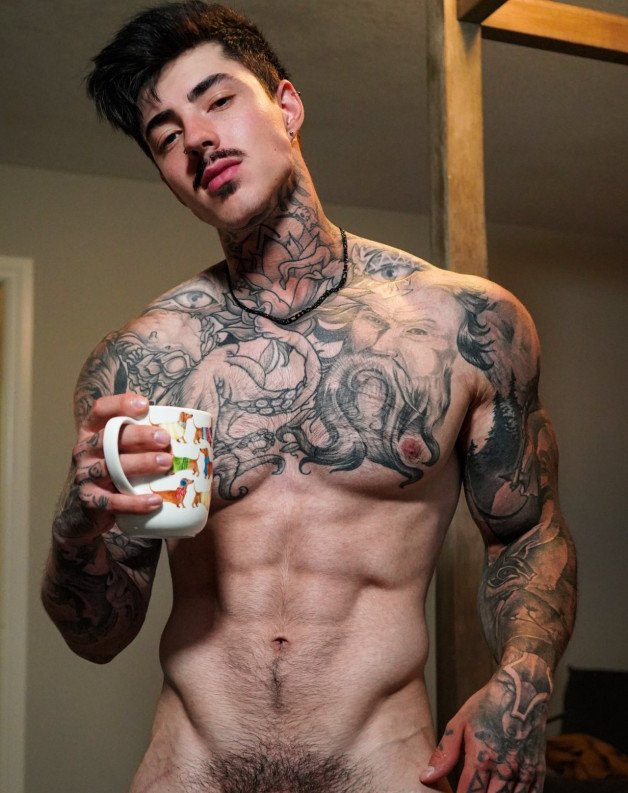 Photo by Nickplus33 with the username @Nickplus33, who is a verified user,  August 26, 2023 at 2:23 AM and the text says '#muscled #ink #coffee #stache #chain #stud #otter #happytrail'