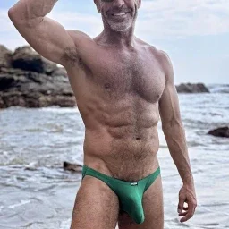 Photo by Nickplus33 with the username @Nickplus33, who is a verified user,  May 2, 2024 at 3:15 AM and the text says '#daddy #muscled #outdoors #beach #hairy #trimmed  #beard #shades #bulge #caps'