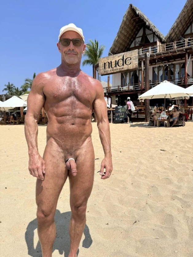 Photo by Nickplus33 with the username @Nickplus33, who is a verified user,  May 2, 2024 at 2:55 AM and the text says '#caps #shades #beach #outdoors #daddy #toned #hairy #hung #cockring #beard #hairychest #scruff'
