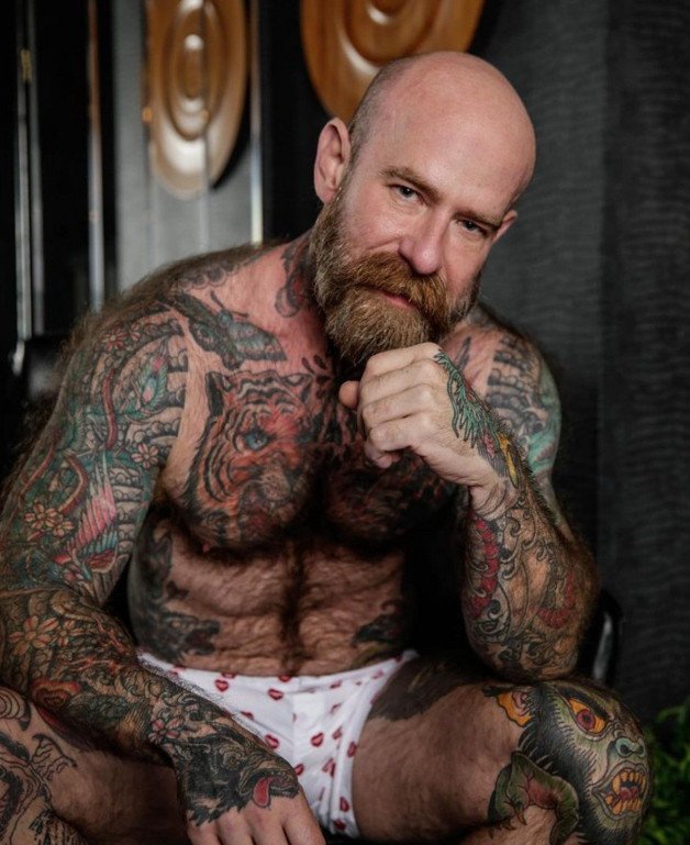 Photo by Nickplus33 with the username @Nickplus33, who is a verified user,  January 3, 2024 at 5:35 AM and the text says '#daddy #bald #hairy #bear #beard #obsession #JackDixon #ink #boxers'