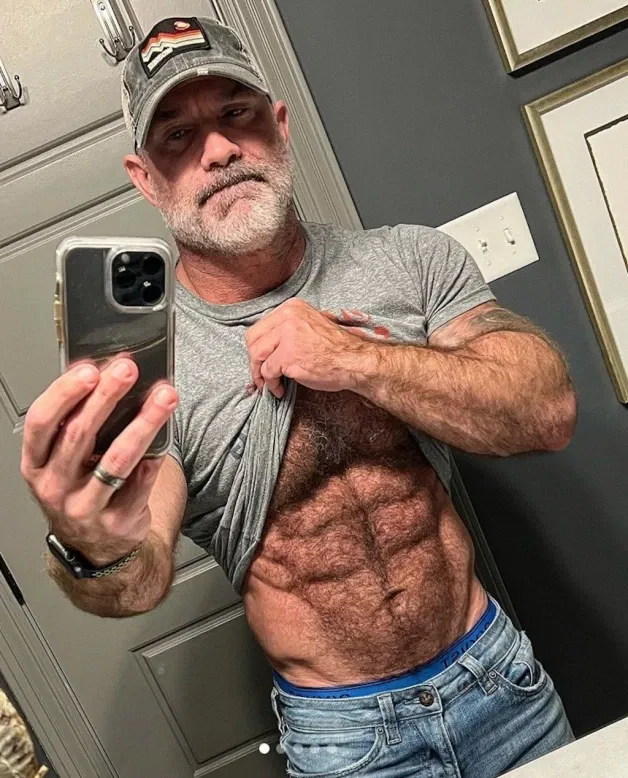 Photo by Nickplus33 with the username @Nickplus33, who is a verified user,  March 24, 2024 at 3:49 AM and the text says '#caps #daddy #muscled #hairy #beard #band #selfies'