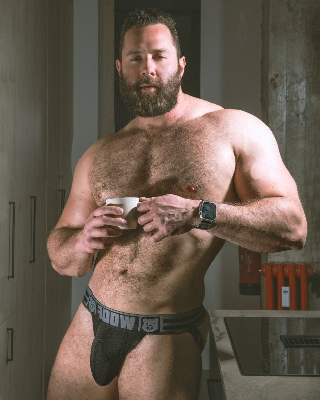 Photo by Nickplus33 with the username @Nickplus33, who is a verified user,  June 27, 2024 at 2:21 AM and the text says '#hairy #bear #daddy #dilf #beard #jockstrap #bulge #coffee'