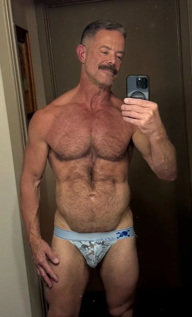 Photo by Nickplus33 with the username @Nickplus33, who is a verified user,  March 28, 2024 at 3:11 AM and the text says '#selfie #daddy #stache #granddaddy #muscled #hairy #trimmed  #hairychest #trimmed  #hung #schlong'