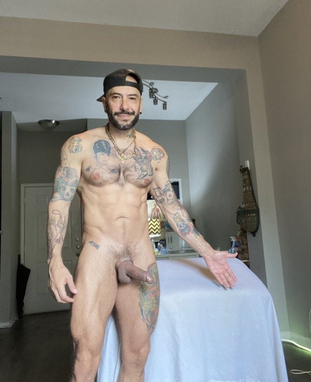 Photo by Nickplus33 with the username @Nickplus33, who is a verified user,  April 19, 2024 at 1:59 AM and the text says '#chain #beard #caps #ink #dilf #toned #caps #hung #thickdick #trimmed  #cockring'