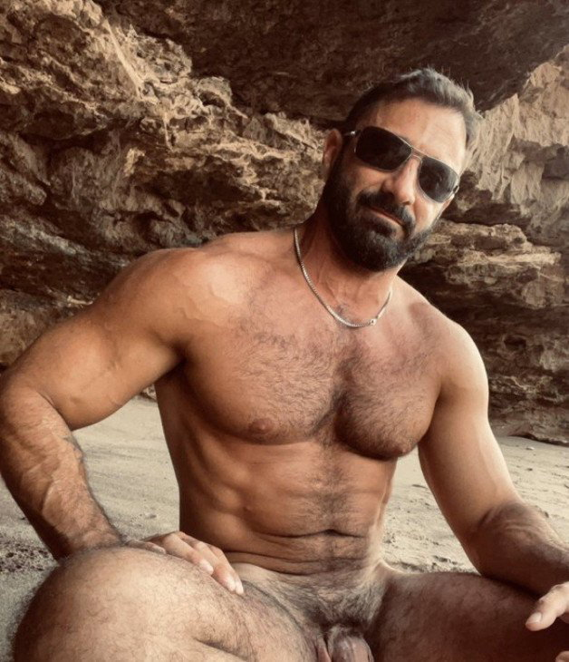Photo by Nickplus33 with the username @Nickplus33, who is a verified user,  June 23, 2024 at 3:23 AM and the text says '#outdoorcruising #outdoors #daddy #shades #manspread  #hairy #trimmed  #chain #beard #muscled'