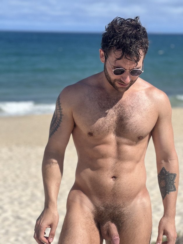 Photo by Nickplus33 with the username @Nickplus33, who is a verified user,  April 19, 2024 at 1:57 AM and the text says '#outdoors #shades #youngdilf #beach #toned #bush #scruff  #ink'