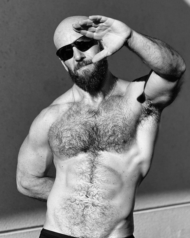 Photo by Nickplus33 with the username @Nickplus33, who is a verified user,  April 25, 2024 at 2:21 AM and the text says '#blackandwhite #dilf #bald #beard #shades #hairy #toned'