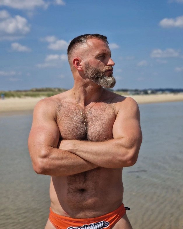 Photo by Nickplus33 with the username @Nickplus33, who is a verified user,  June 25, 2024 at 2:15 AM and the text says '#dilf #outdoors #beard #beach #hairy #chain #trimmed  #hairychest #Marius #obsession'