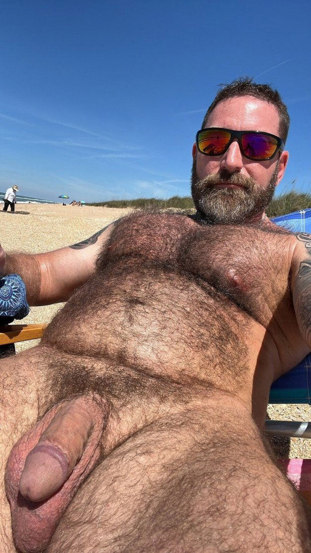 Photo by Nickplus33 with the username @Nickplus33, who is a verified user,  July 5, 2024 at 1:04 AM and the text says '#daddy #beefy #hairy #outdoors #shades #bear #manspread'