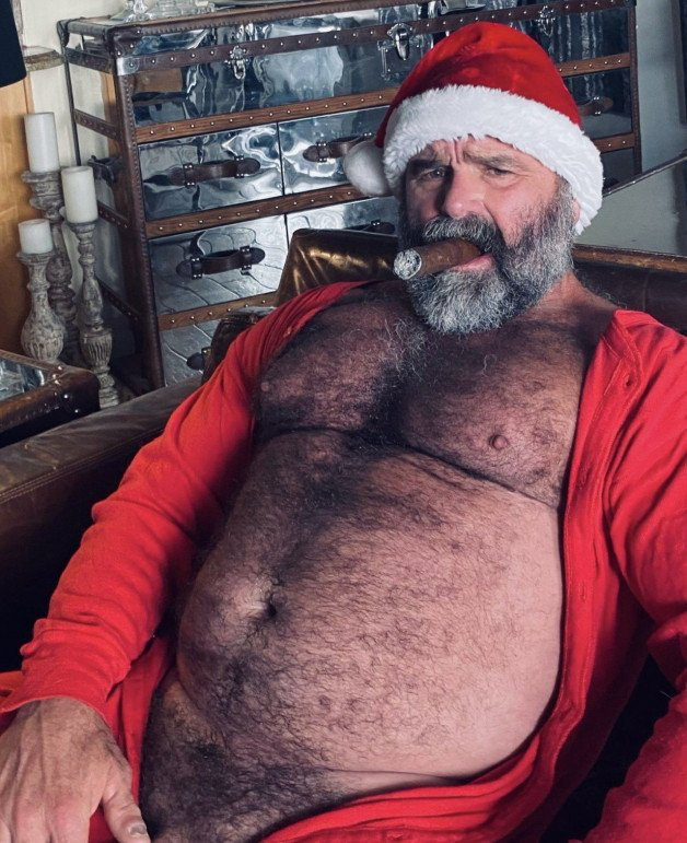 Photo by Nickplus33 with the username @Nickplus33, who is a verified user,  December 25, 2023 at 5:15 AM and the text says '#beefy #daddy #beard #santa #hairy #cigar #granddaddy #bush'
