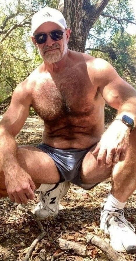 Photo by Nickplus33 with the username @Nickplus33, who is a verified user,  July 4, 2024 at 2:53 AM and the text says '#caps #hairy #manspread  #bulge #shades #daddy #outdoors #hairychest #granddaddy'