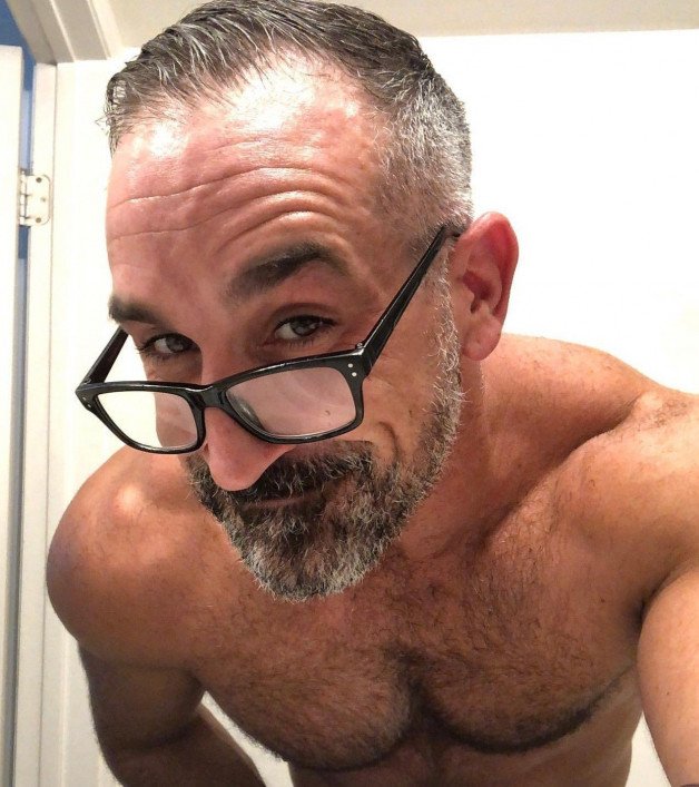 Photo by Nickplus33 with the username @Nickplus33, who is a verified user,  January 4, 2024 at 7:56 AM and the text says '#beard #daddy #specs #HunterX #obsession #hairy #toned'