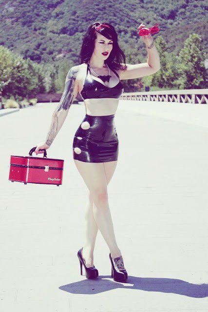 Photo by LatexAngel with the username @LatexAngel, who is a star user,  July 22, 2015 at 9:01 AM and the text says 'The proper way of hitchhiking. :) #BlackLatexBra #BlackLatexShortPants #HighHeels #tattoo #fetish:    ow.ly/NSEM6'